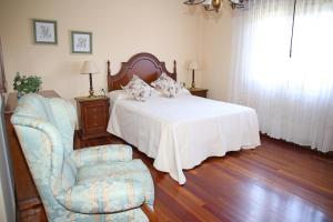 a bedroom with a bed and a chair and a window at Os de Rey in Pontevedra +46 photos