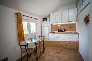een keuken met een tafel en stoelen in een kamer bij Studio apartment Villa Radovic in Strp