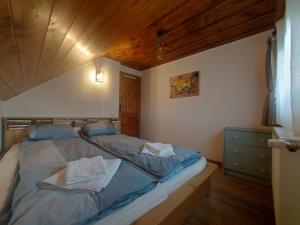 1 cama en un dormitorio con techo de madera en Cabana din Rusca, en Sebeşu de Jos