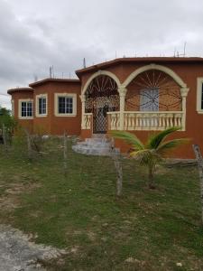 a house with a balcony on the front of it at fee easy studio, in 15 minutes away you can locate YS FALLS, 5 mins way safari tour, HALF HOUR there come LOVERS LEAP, pelican bar, treasure beach, Appleton easte..and the list goes on in Black River
