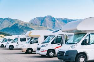 斯塔沃洛的住宿－GPtents Camping - Spa，停在停车场的一排白色卡车