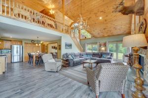 a living room with a couch and a table at 3-Acre Benezette Cabin Hot Tub, Grill and Mtn View in Benezette