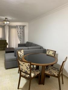 sala de estar con mesa, sillas y sofá en شالية Golden Beach 1, en Raʼs Matarma
