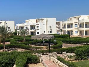 a garden in front of a large building at Chalet 5s Golden beach 1Families only in Raʼs Matarma