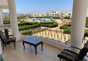 a balcony with chairs and a table and a pool at Chalet 5s Golden beach 1Families only in Ras Matarma