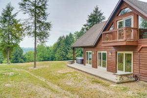 a log home with a deck and a house at 3-Acre Benezette Cabin with Hot Tub, Grill and Mtn View in Benezette
