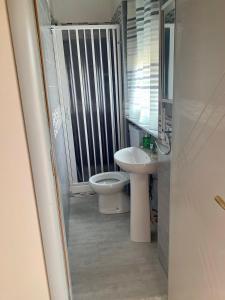 łazienka z toaletą i umywalką w obiekcie La casetta del mare w mieście Gela