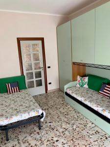 2 łóżka w pokoju zielonym i białym w obiekcie La casetta del mare w mieście Gela