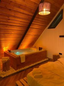 uma grande banheira de madeira num quarto com 2 camas em OYARC SAPANCA VILLA / BUNGALOW em Sakarya