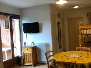 a dining room with a table and a television on the wall at Appartement Enchastrayes, 2 pièces, 5 personnes - FR-1-165A-144 in Enchastrayes