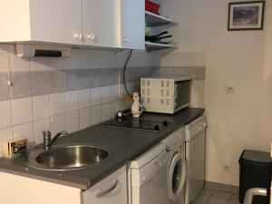 um balcão de cozinha com um lavatório e um micro-ondas em Appartement Enchastrayes, 2 pièces, 5 personnes - FR-1-165A-144 em Enchastrayes