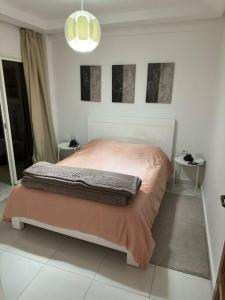 1 dormitorio con 1 cama con manta rosa en appartement center de Guéliz avec piscine, en Marrakech