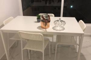 Una mesa blanca con sillas y un jarrón encima. en appartement center de Guéliz avec piscine, en Marrakech 12 fotos más