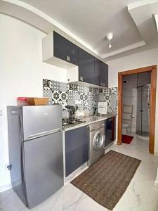 una cocina con nevera y lavadora en appartement center de Guéliz avec piscine, en Marrakech