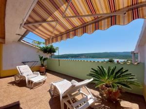 un patio con sillas y vistas al agua en Apartments Marica, en Čižići