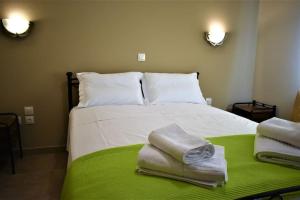 a bedroom with a bed with towels on it at Smailis apartment 1 in Koróni