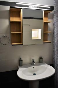 a bathroom with a white sink and a mirror at Smailis apartment 1 in Koróni
