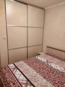 a small bedroom with two beds and a closet at Ellie's place in Bitola