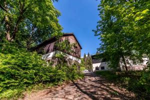 an old barn with trees on the side of a road at Chata Barbora in Lučany nad Nisou