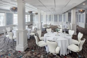a banquet room with white tables and white chairs at Ashworth by the Sea in Hampton