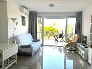 Un dormitorio con una cama y un escritorio y un balcón. en Panorama, en Torrox Costa
