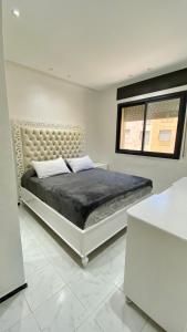 a white bedroom with a large bed and a window at Big appartment near soccer stadium in Tangier in Tangier