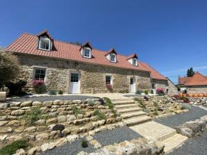 a stone house with a stone walkway in front of it at la grange in Offrethun