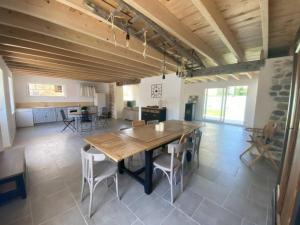 a kitchen and dining room with a wooden table and chairs at la grange in Offrethun