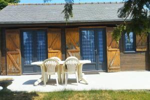 Meillac的住宿－Petit chalet à la campagne，小屋前的两把椅子和一张桌子