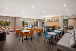 a restaurant with tables and chairs and a couch at Hawthorn Extended Stay by Wyndham Sulphur Lake Charles in Sulphur