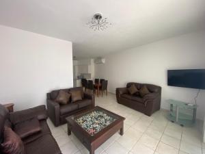 ein Wohnzimmer mit 2 Sofas und einem TV in der Unterkunft Corner townhouse in Regina Gardens, Pafos in Paphos City