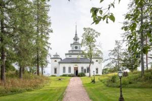 a large white building with a clock tower on top at Kiiski Home in Teijo