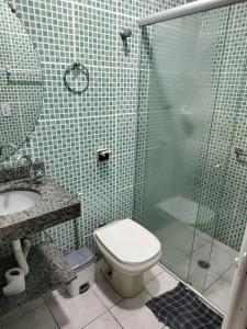 een badkamer met een douche, een toilet en een wastafel bij Apartamento bem localizado. in Praia Grande