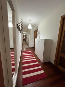 een hal met een rood en wit gestreept tapijt op de vloer bij La Capilla in Ribadesella