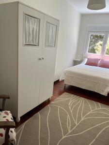 een witte slaapkamer met een bed en een raam bij La Capilla in Ribadesella