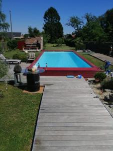 uma piscina com um passadiço de madeira ao lado de um quintal em On dirait le Sud 