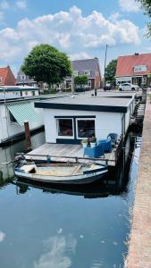 a small boat is docked next to a dock at Woonboot 4 Harderwijk in Harderwijk