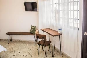 two tables and chairs in a room with a window at M&uacute;cara hotel in Veracruz