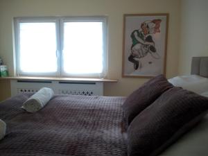 a bedroom with a bed with two windows and a bedspread at POLKA in Schwarzenbach an der Saale
