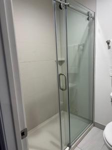 a shower with a glass door in a bathroom at La Casa Motel, Los Angeles - Burbank Airport in Sun Valley