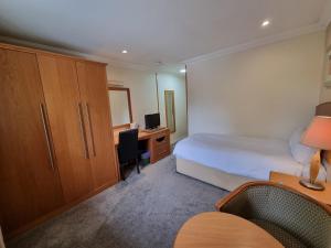 a bedroom with a bed and a desk with a computer at Kegworth Hotel & Conference Centre in Castle Donington