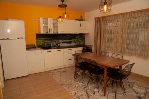 eine Küche mit einem Tisch und Stühlen sowie einem Kühlschrank in der Unterkunft Vila Omar in Sarajevo