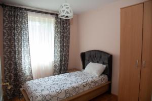 Schlafzimmer mit einem Bett und einem Fenster in der Unterkunft Vila Omar in Sarajevo