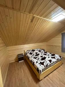 a bedroom with a bed in a wooden room at Pid lisochkom in Verkhovyna