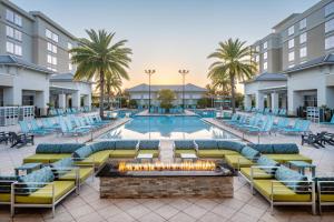 uma piscina exterior com espreguiçadeiras e uma fogueira em TownePlace Suites Orlando at FLAMINGO CROSSINGS® Town Center/Western Entrance em Orlando