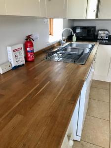 a kitchen with a sink and a wooden counter top at Mulberry Barn Annx - Self Contained Near Winchester in Micheldever
