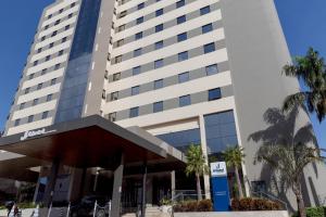 a building with palm trees in front of it at JL Hotel by Bourbon in Foz do Iguaçu