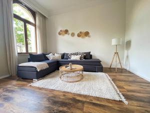 a living room with a blue couch and a table at Bamboo City in Magdeburg