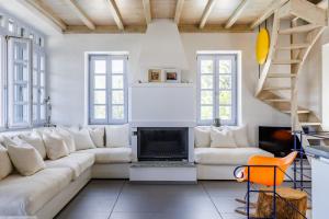 Una sala de estar con un sofá blanco y una chimenea. en Villa Almond, en Skopelos Town