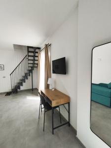 um quarto com uma secretária, uma televisão e um sofá em La Puteca em Nápoles